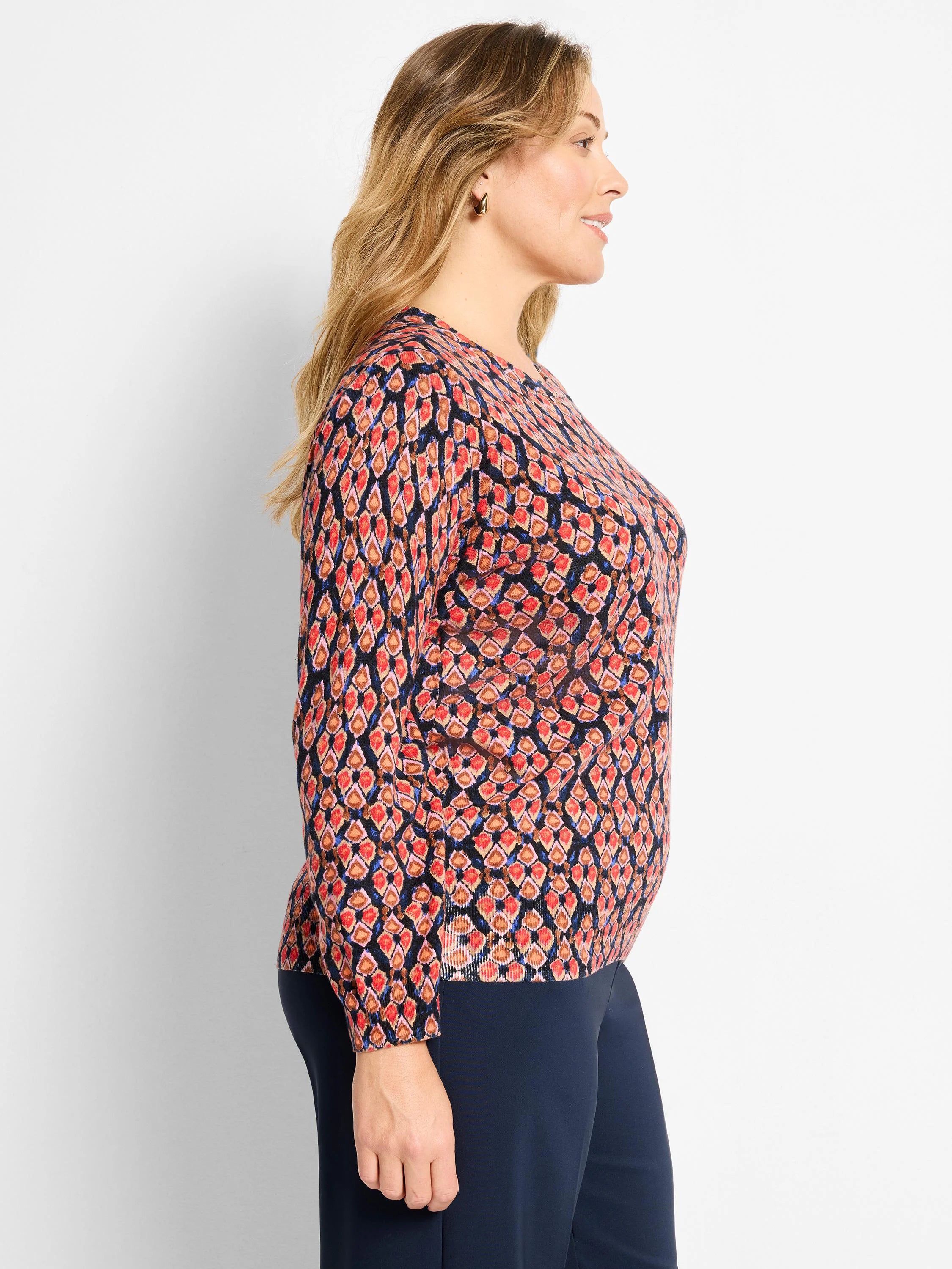Dark navy sweater with red, orange, and blue ikat diamond pattern. Round neck, long sleeves.