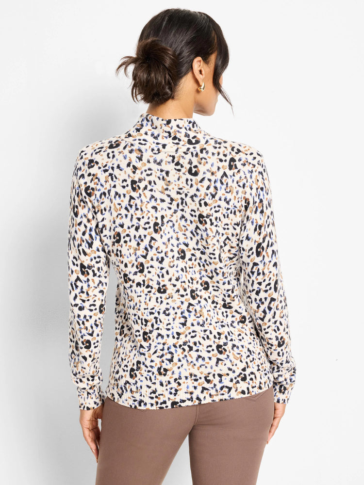 Back view of a cream mock-neck sweater with black, brown, and blue cheetah print spots.