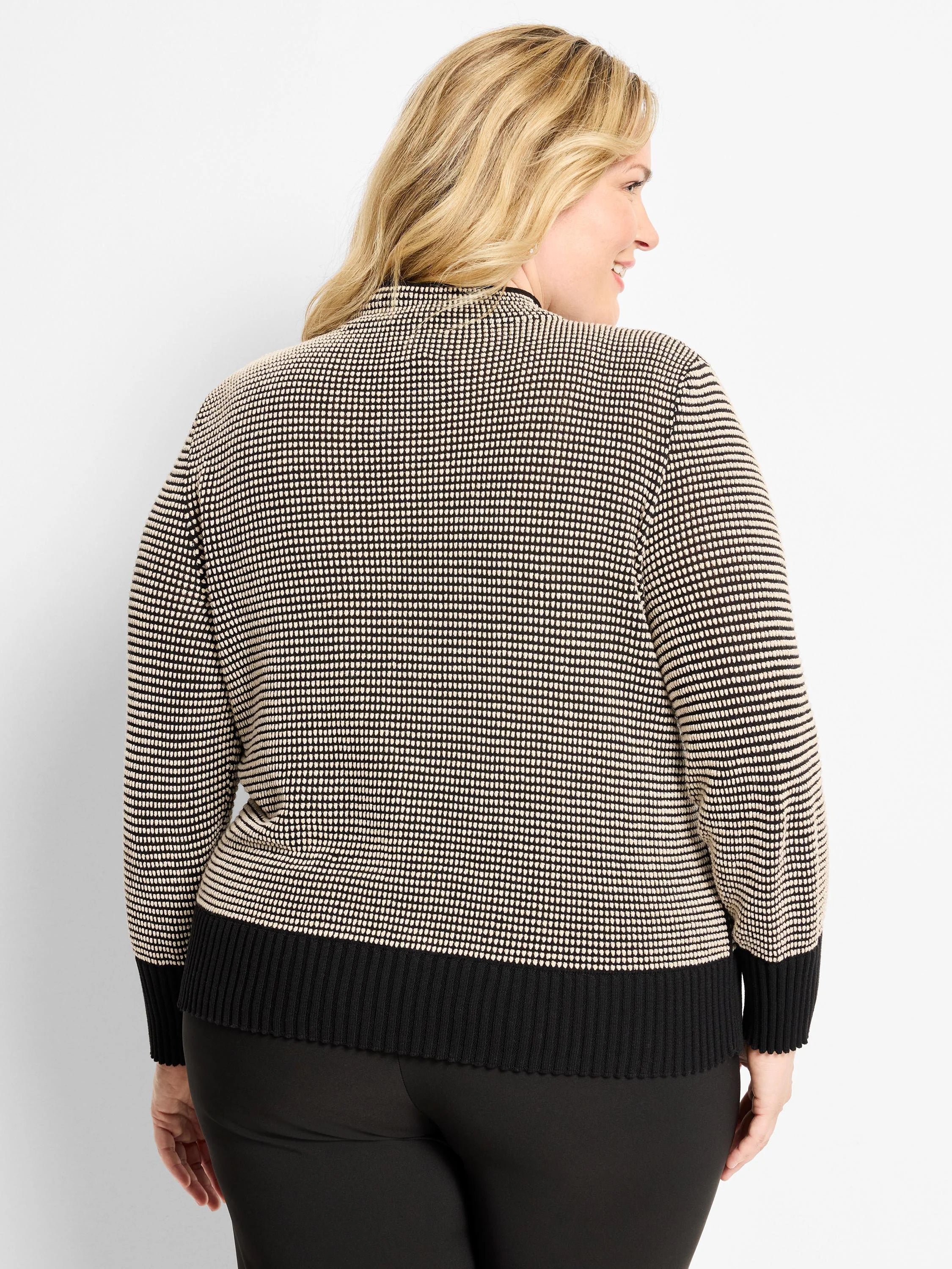 Black and cream pixel knit funnel neck sweater, shown from behind. Features ribbed black cuffs and hem.