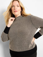 Black and beige pixel knit funnel neck sweater with solid black ribbed cuffs and hem.