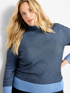 Black and light blue pixel knit funnel neck sweater with ribbed cuffs and hem.