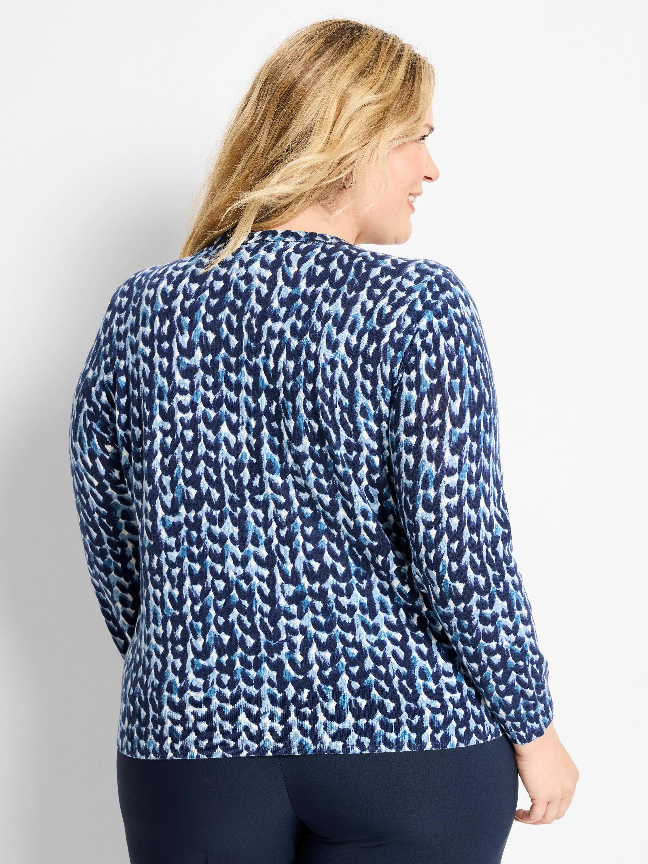 Long-sleeved sweater with a mottled knit stitch pattern in dark blue, light blue, and white.