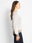 Off-white textured knit sweater with contrasting brown ribbed collar, cuffs, and hem.