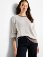 Light beige open knit sweater with brown ribbed collar, cuffs, and hem.