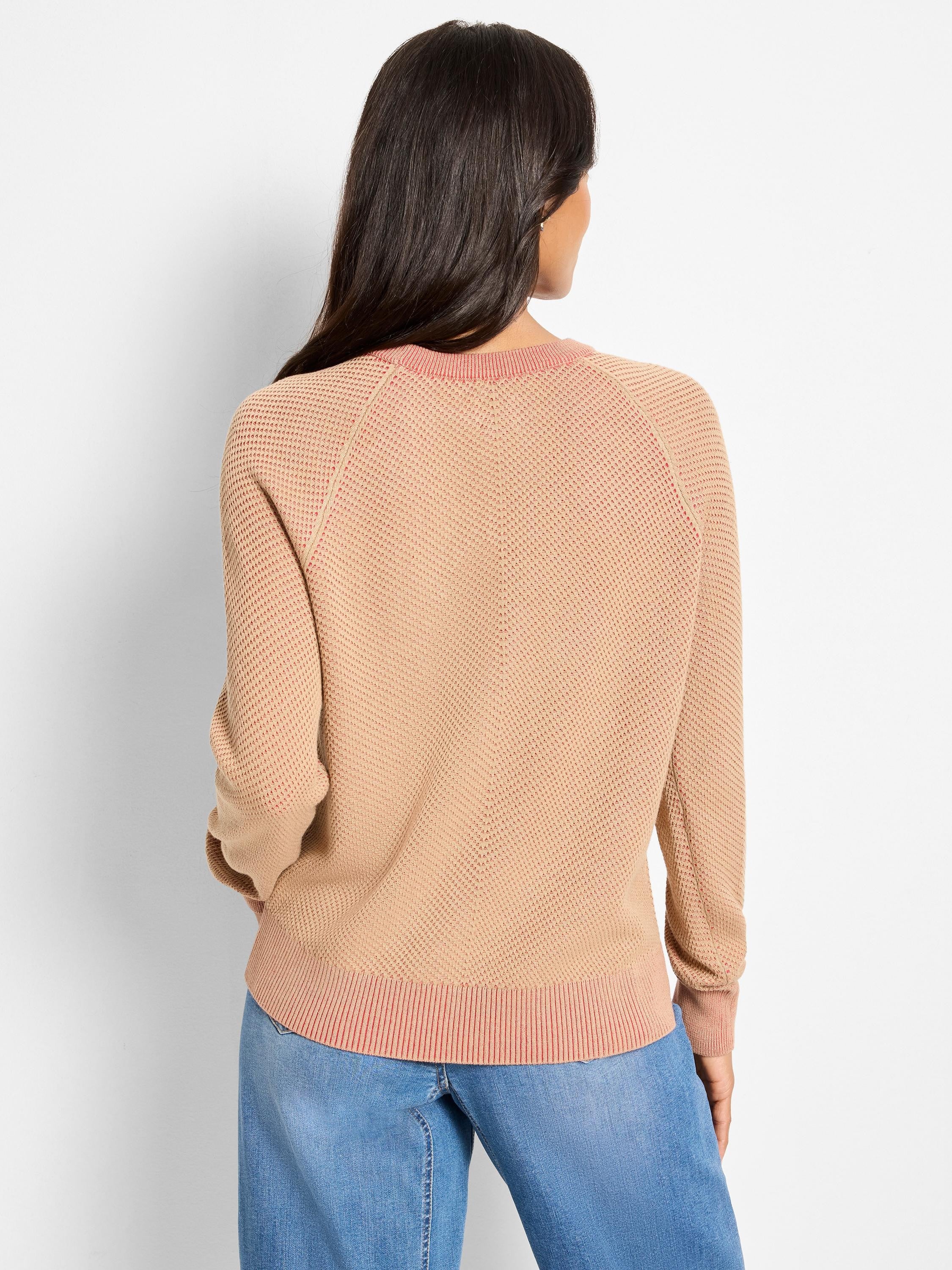 Tan textured sweater with coral pink ribbed collar, raglan seams, and hem. Model from back.
