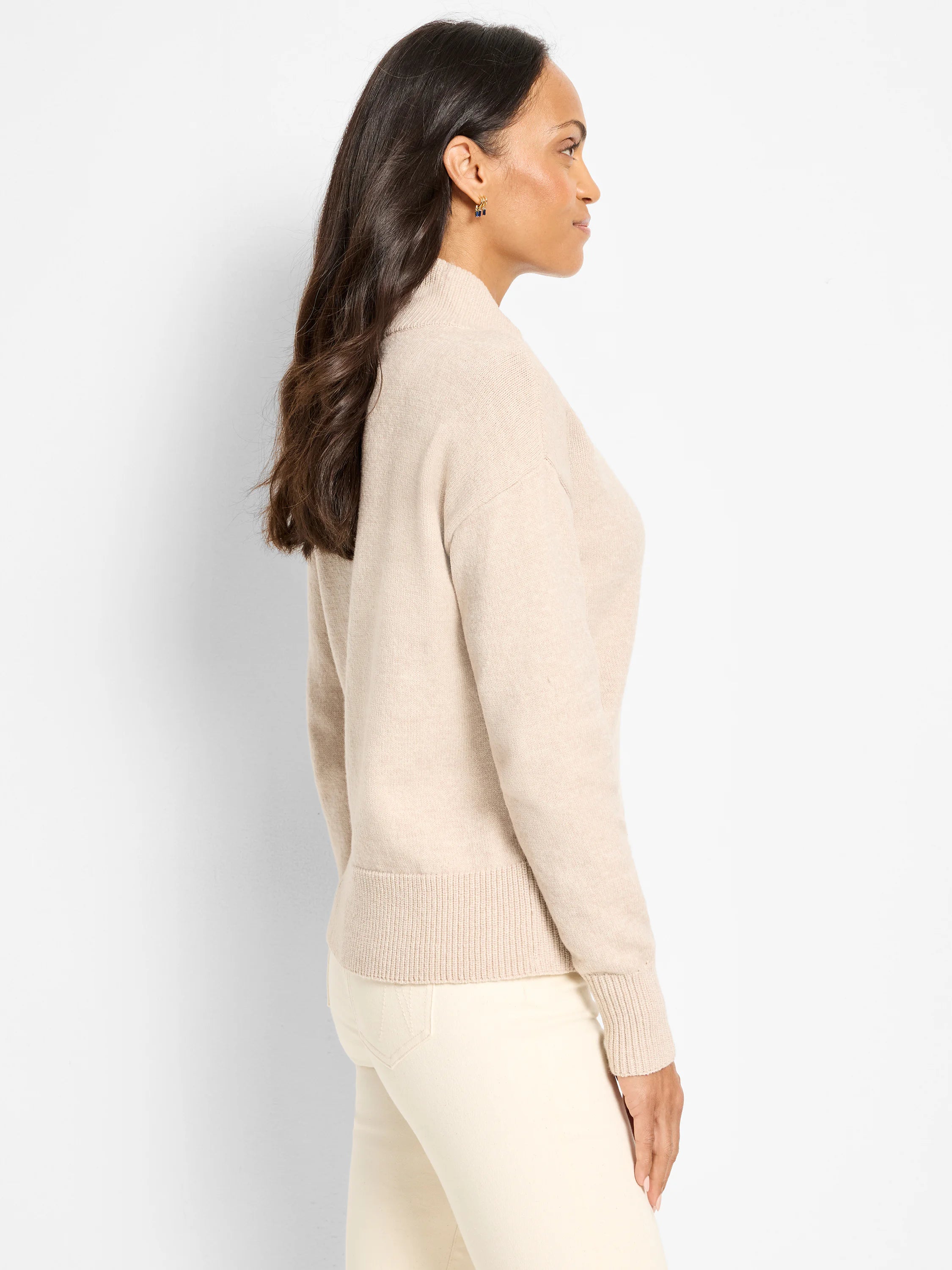 Light beige knit sweater with a mock neck, long sleeves, and ribbed cuffs and hem.