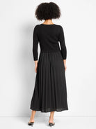 Black Kyrie dress with a ribbed long-sleeve top and a full, pleated maxi skirt.