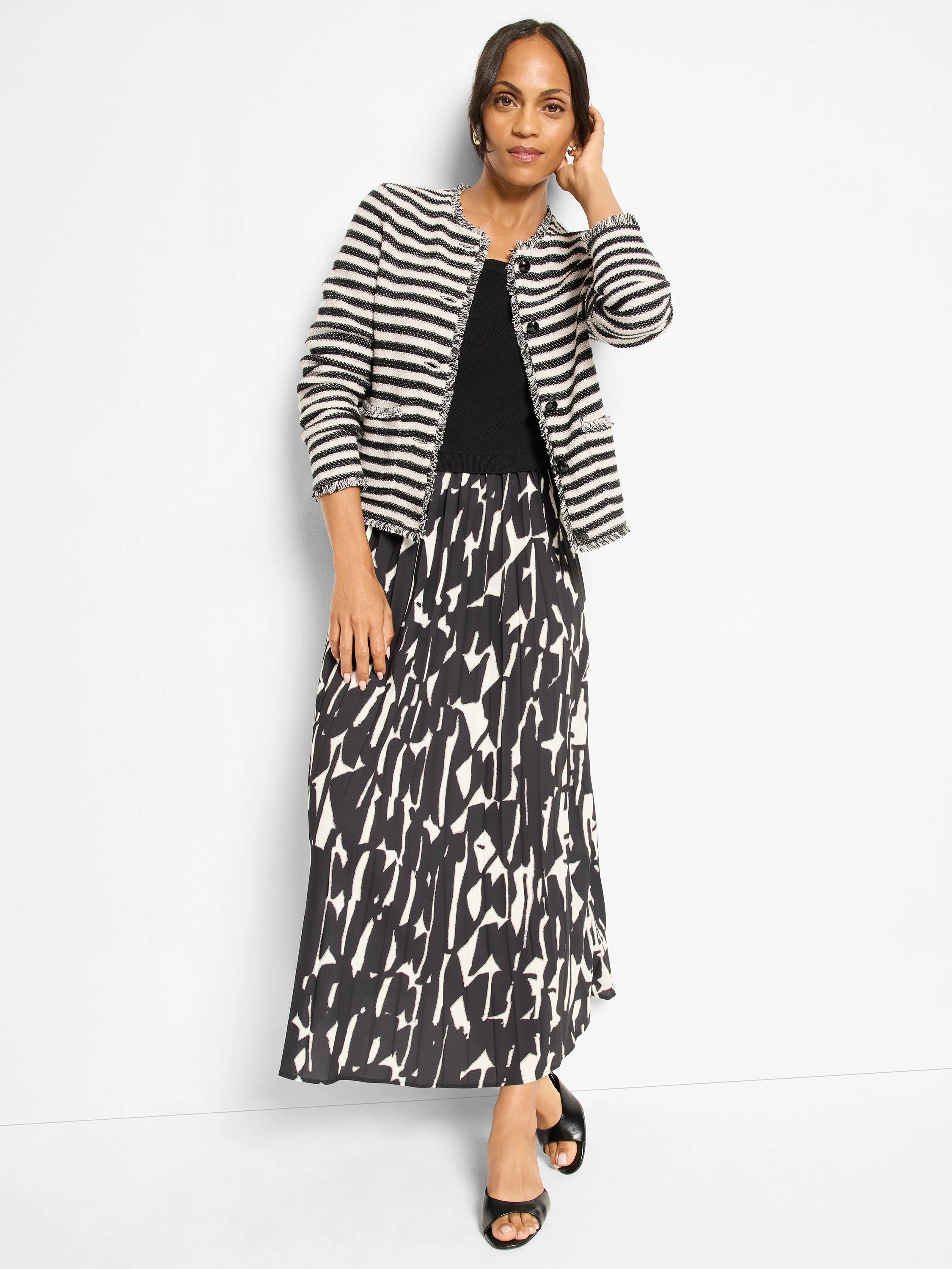 Long, pleated dress with an abstract black and off-white pattern.