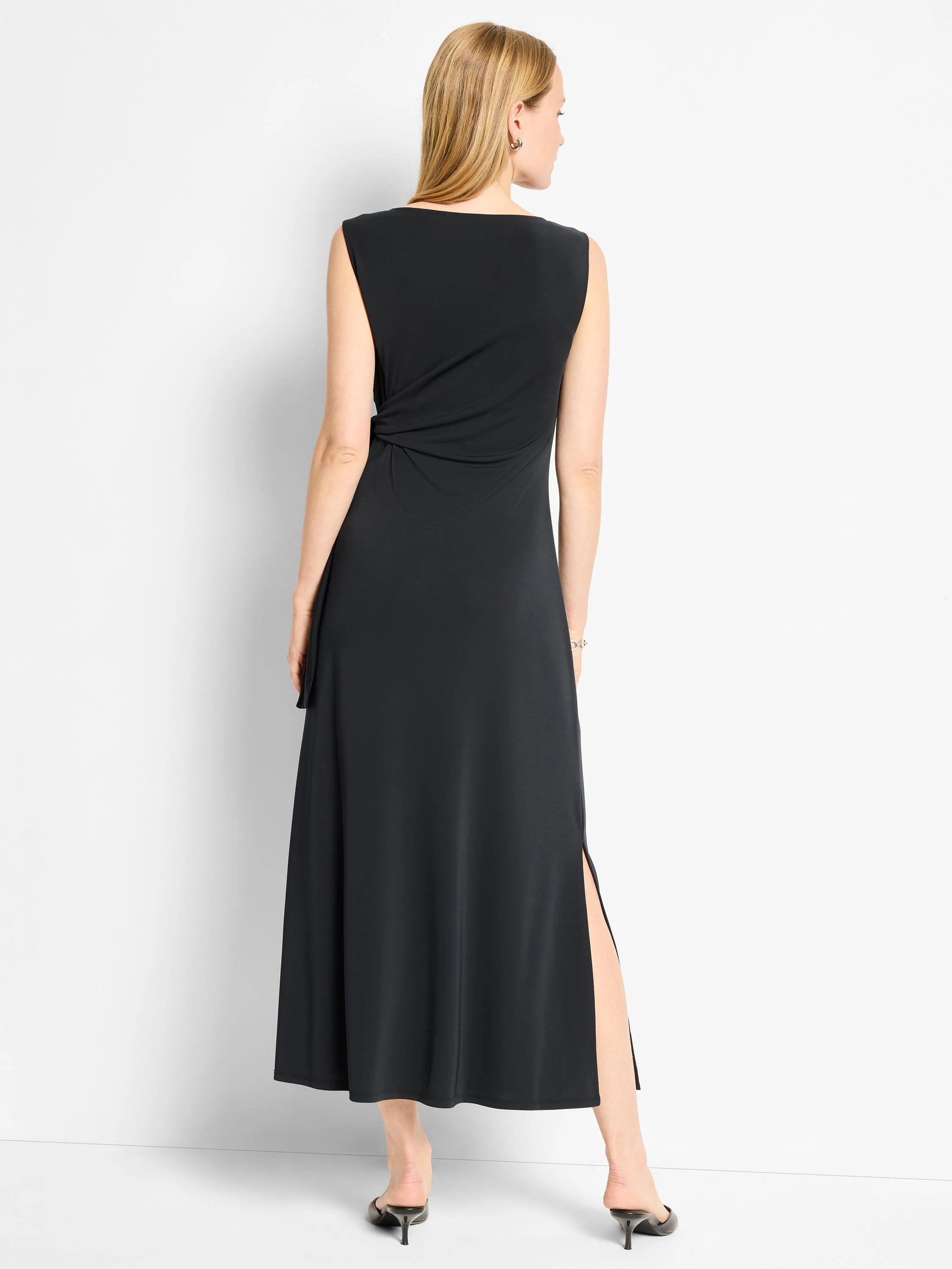 Black sleeveless maxi dress, back view. Features a knot detail at waist and side slit.