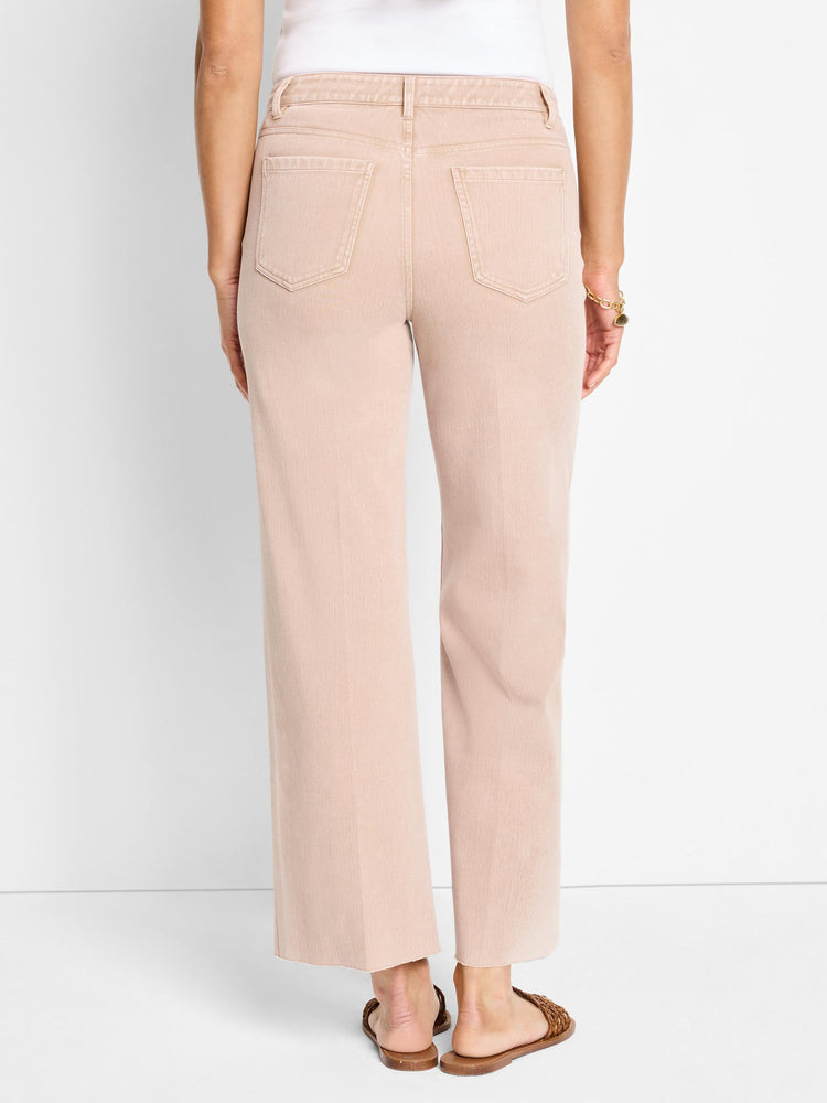 Back view of blush straight-leg knit ankle jeans with rear patch pockets and raw hems.