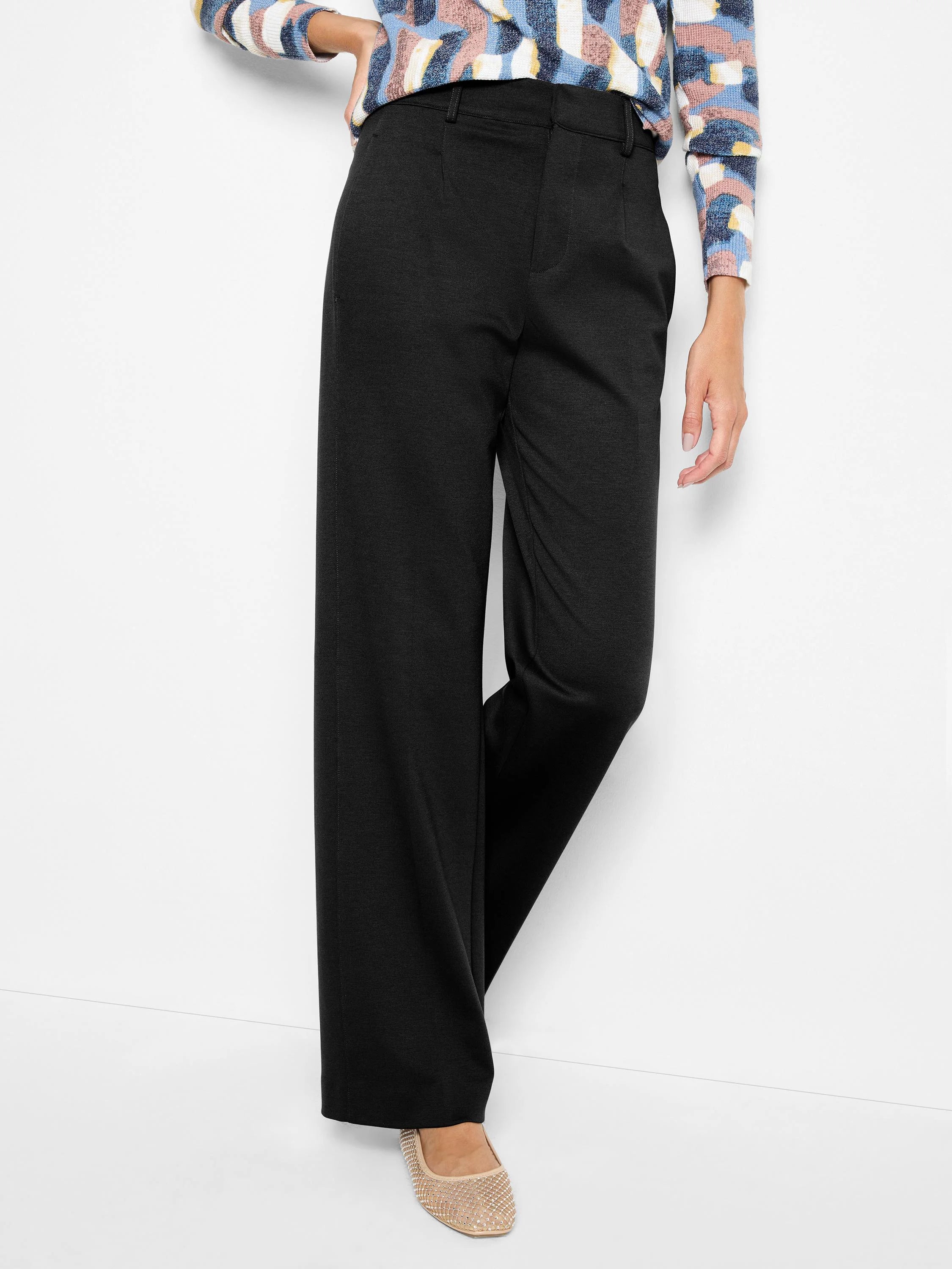 Black, drapey wide-leg trousers. High-waisted, smooth front, with subtle fabric texture.