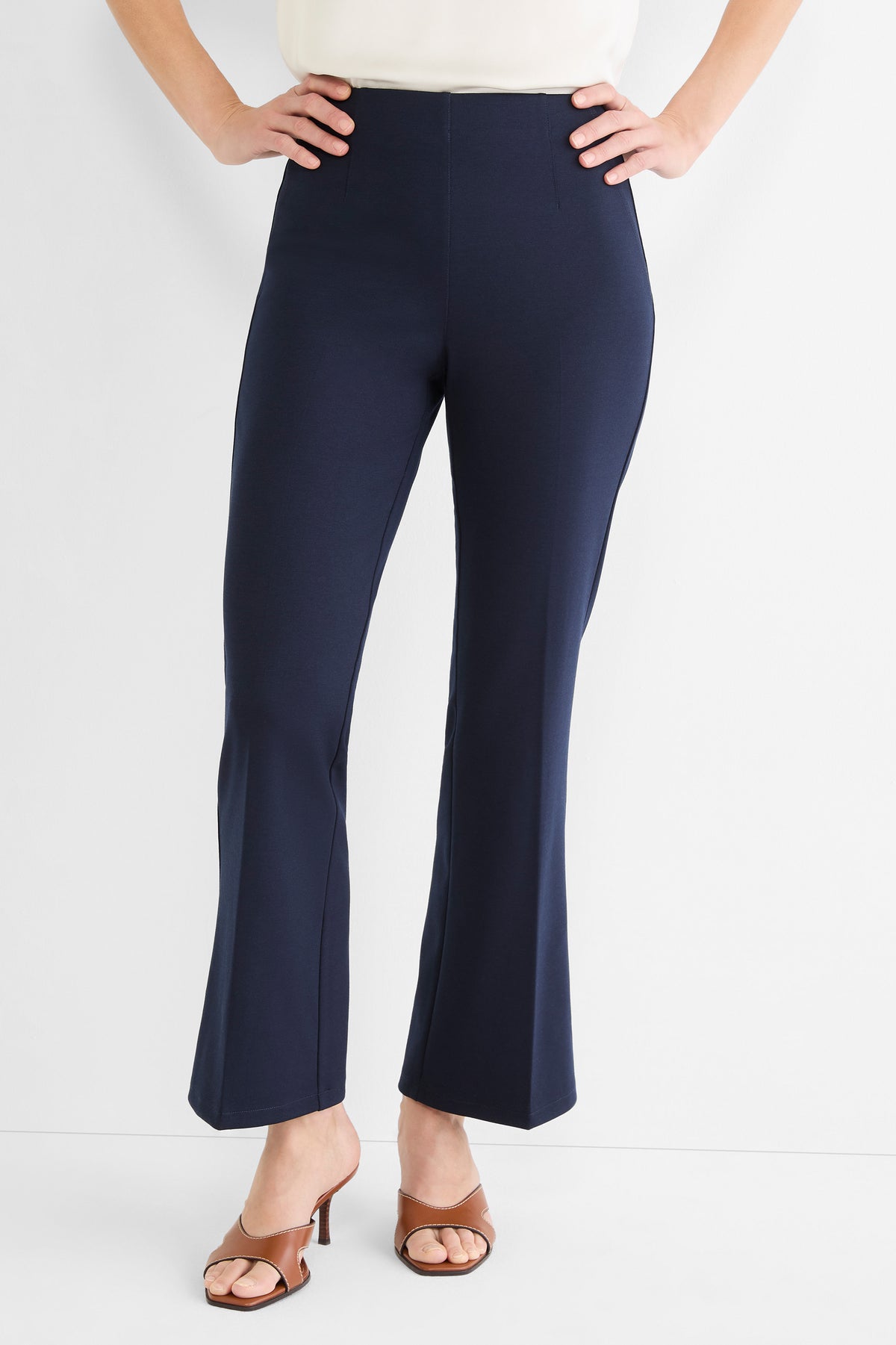 Navy blue high-waisted pull-on pants feature a slim fit through the leg and a modern cropped kick-flare hem.