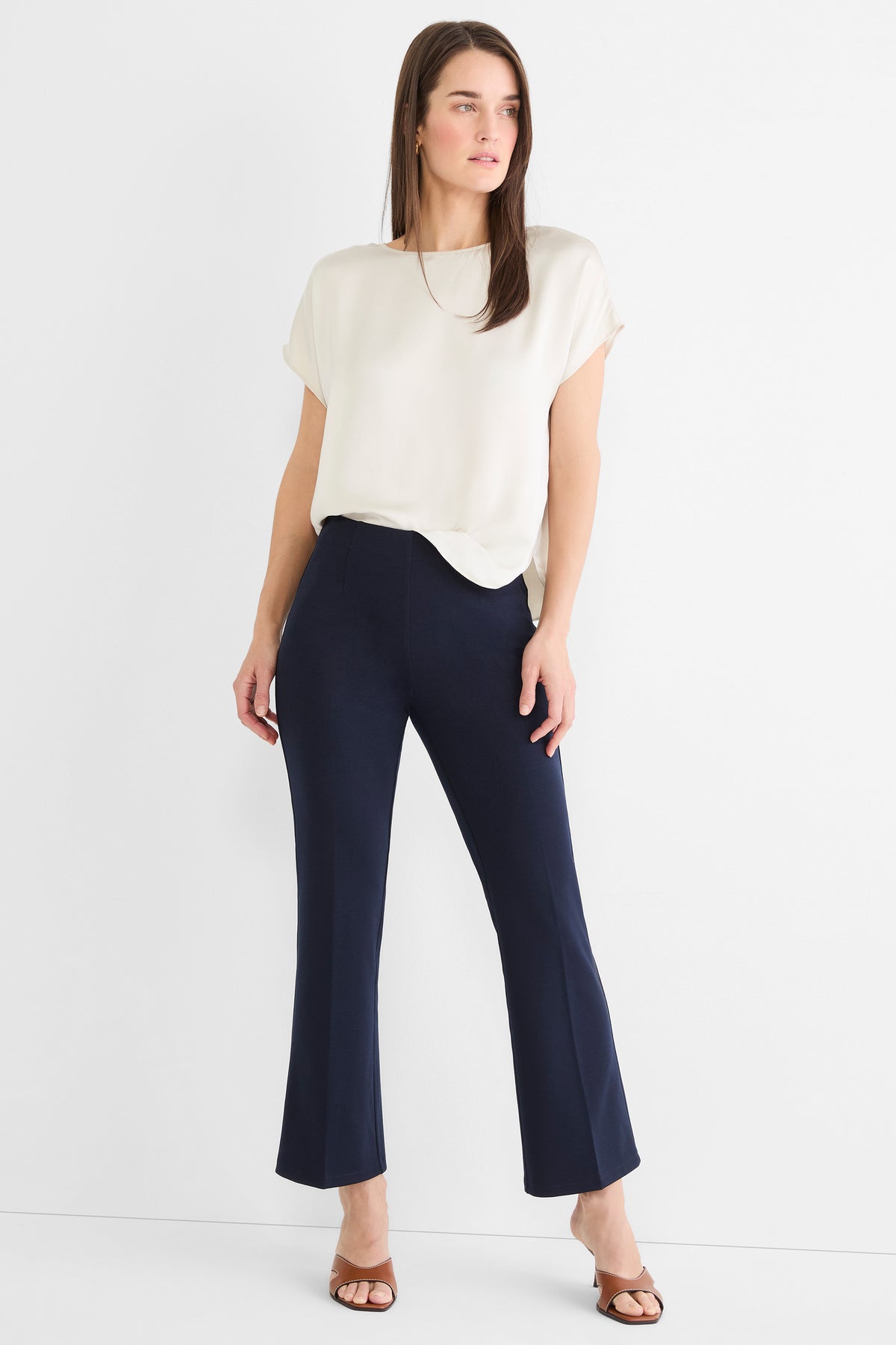 Dark blue high-waisted cropped pants feature a slim fit through the thigh and a subtle flare at the ankle.