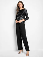 Black wide-leg pants on a model, with a smooth appearance and front creases.