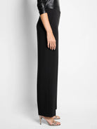 Black wide-leg pant on model, showing a flat front and subtle side pocket.