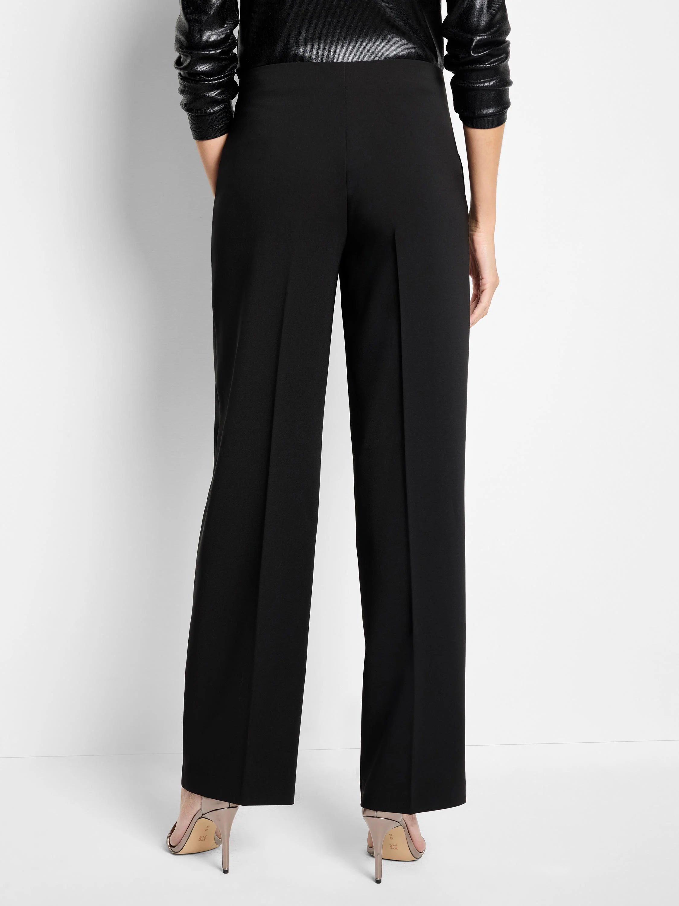 Black wide-leg pants with sharp front creases, shown from the back on a model.