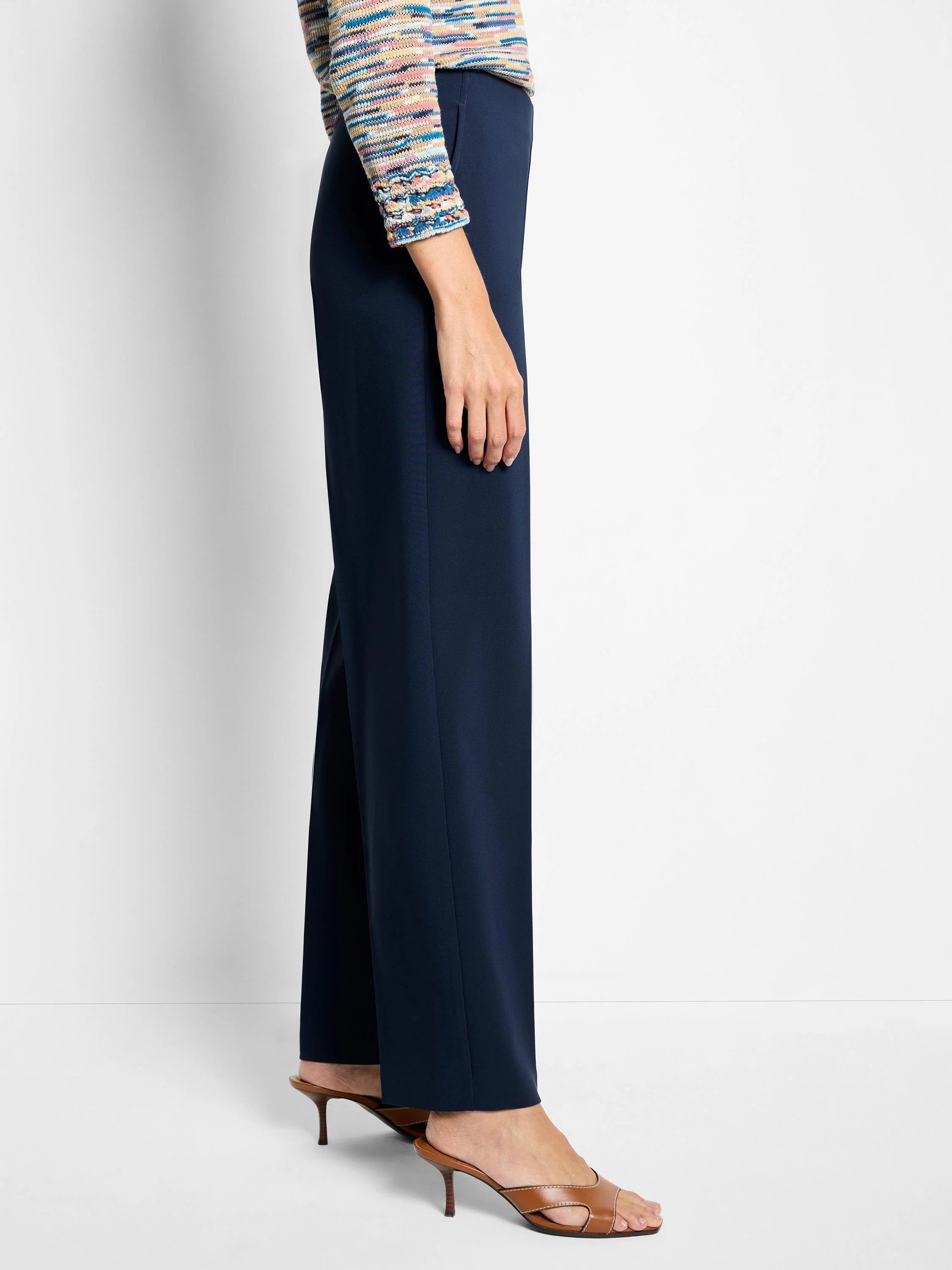 Navy wide-leg pants on a model, from hip to ankle. The fabric appears smooth and drapes to the floor.