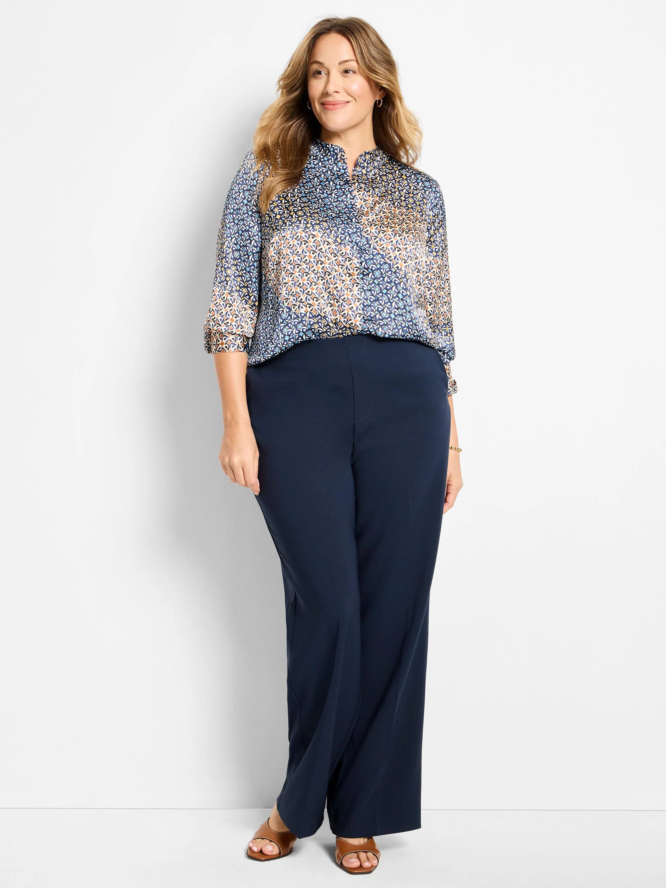 Navy blue wide-leg pants with a sleek finish and vertical front seams, shown on a model.