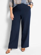 Navy wide-leg pants with a flat front waist, side pockets, and pressed creases down each leg.