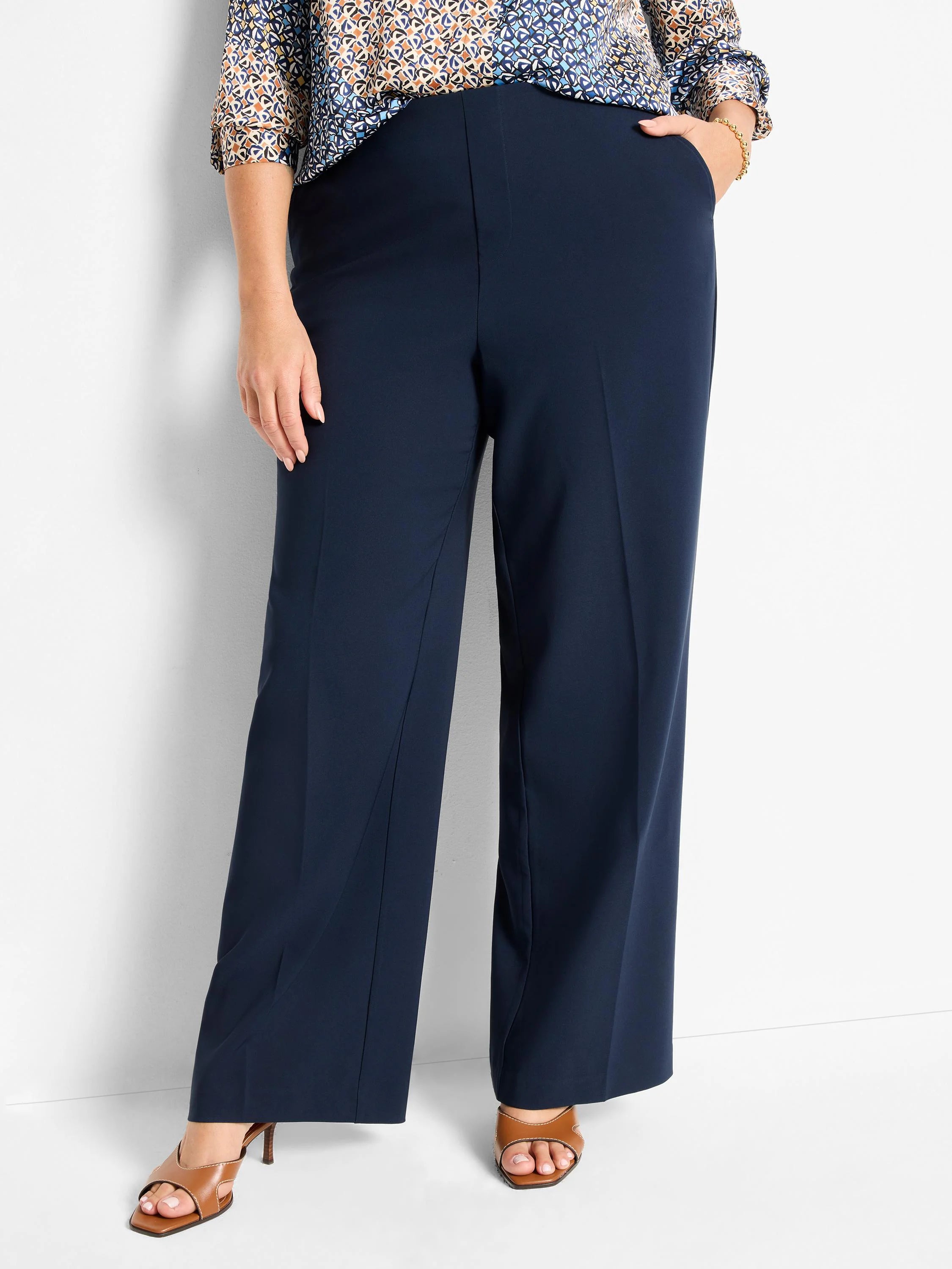 Navy wide-leg pants with a flat front waist, side pockets, and pressed creases down each leg.