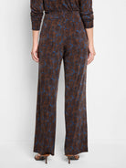 Wide-leg pants; blue background with brown feather-like pattern.