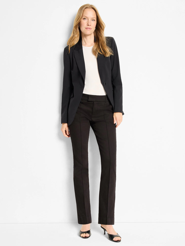 Black blazer, single button, worn with black pants and black shoes. Off-white top underneath.