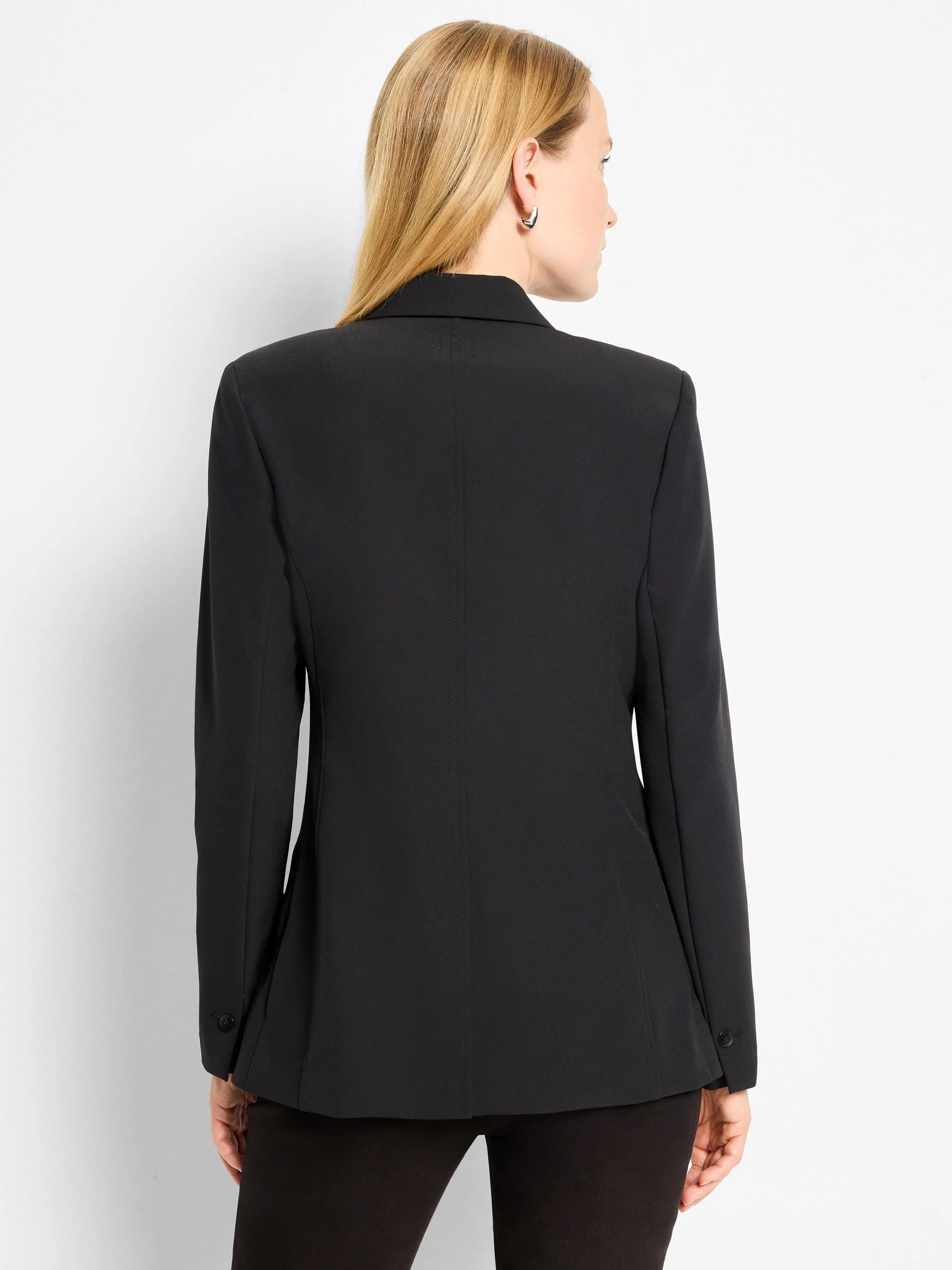 Black blazer, back view.  Structured shoulders, long sleeves, buttoned cuffs.