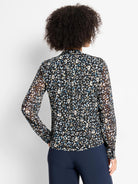 Black sheer long-sleeve top with white, blue, and tan cheetah spots, stand collar, shown tucked.