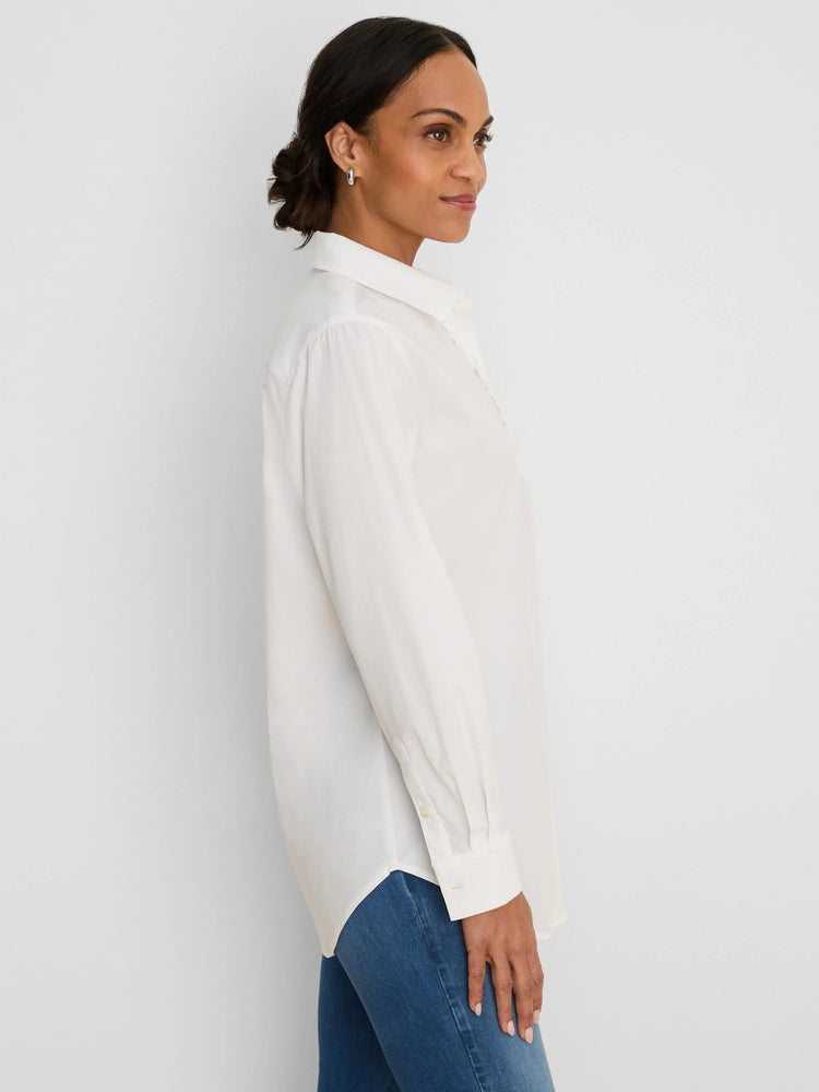 White collared, long-sleeved shirt with subtle ruffle trim. Features a relaxed fit and curved hem.