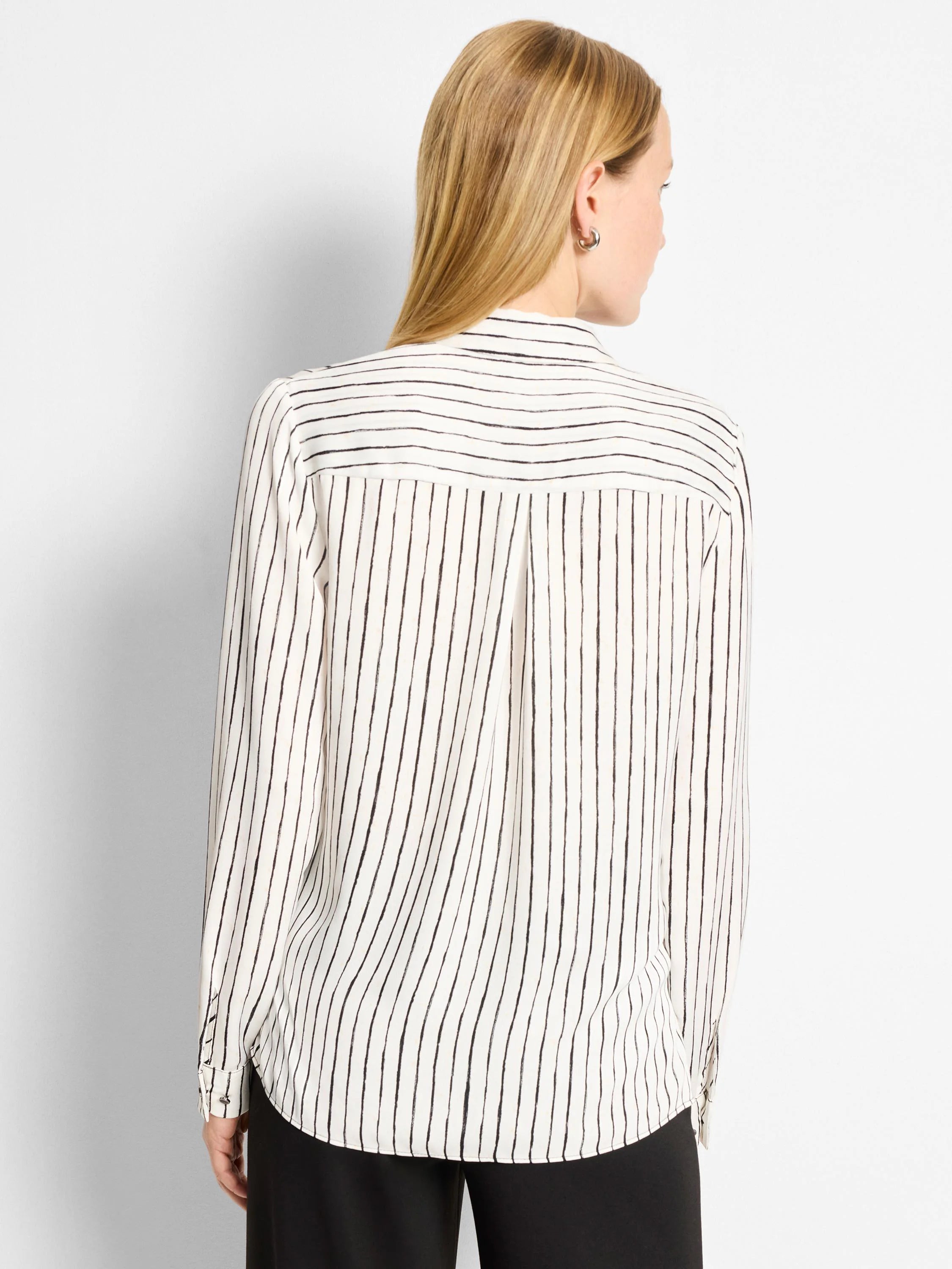 White shirt with thin, painted-look black stripes. Vertical on body, horizontal on back yoke. Long sleeves.