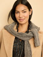 A black shirt with thin, irregular vertical stripes in cream and golden brown.