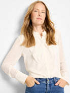 Ecru sheer chiffon long-sleeve top with crinkled texture, band collar, and vertical frayed ruffle placket.