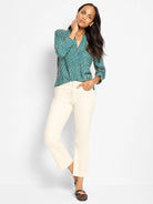 Dark teal V-neck top with a dense cream irregular dot pattern. Long sleeves.