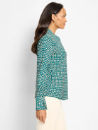 Teal long-sleeved top with light beige shadow dots and a band collar.