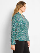 Dark teal long-sleeve top with a cream shadow dot pattern and V-neck.