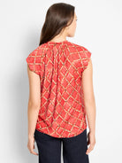 Reddish-orange cap sleeve top with white check & dark squiggle pattern, gathered back.