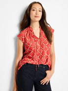 Red cap sleeve top with a beige & black squiggle check pattern, V-neck, and drawstring ties.