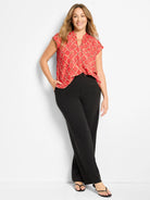 Red-orange cap sleeve top with a light squiggle check pattern, ruffled split V-neck, and relaxed fit.