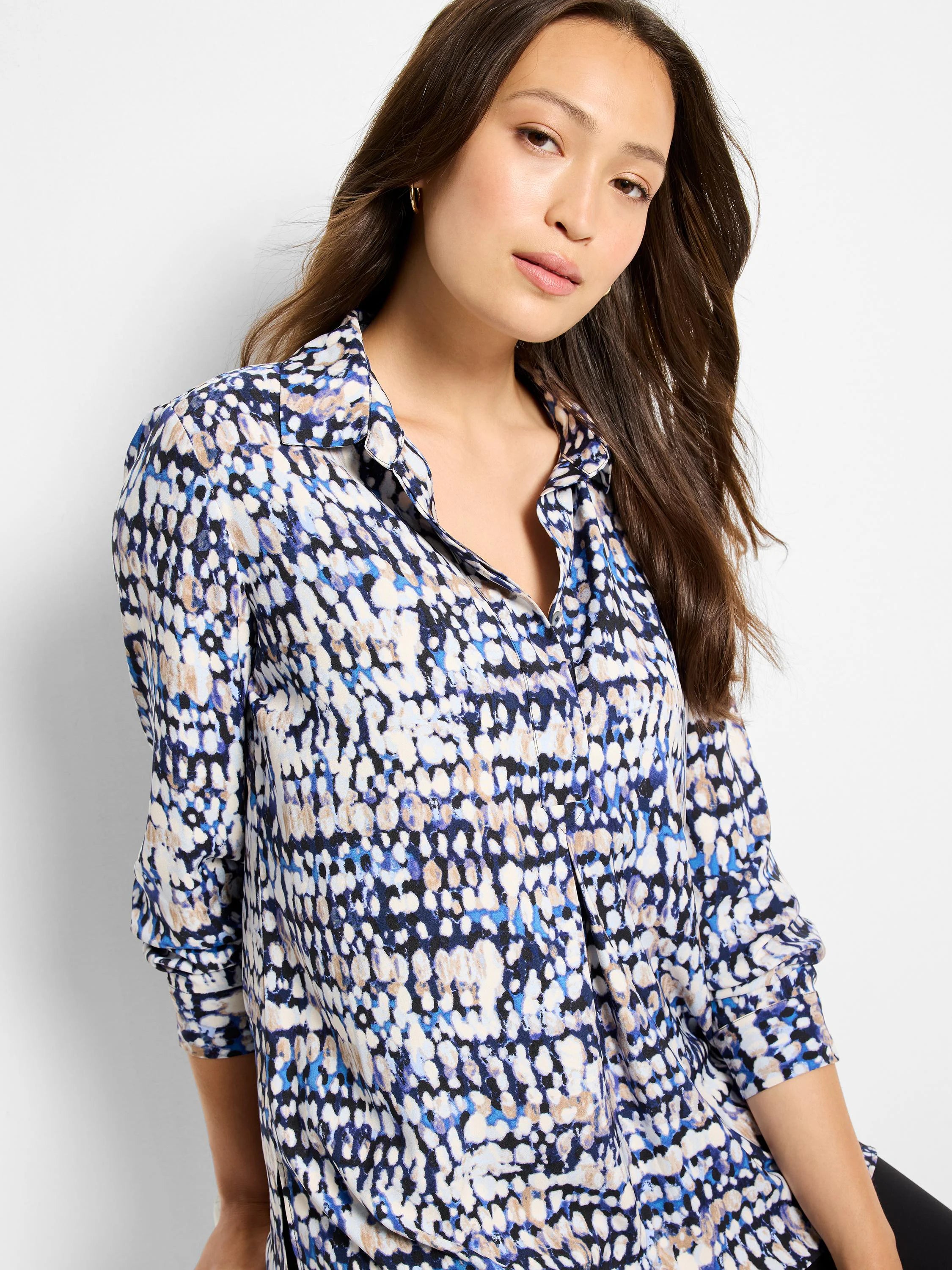 Collared button-down shirt with an abstract dot print in blue, cream, tan, and black.
