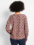 Navy long-sleeve top with rust, peach, tan, and blue ikat diamond pattern. Back view.