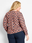 Long-sleeve top: geometric ikat pattern in dark blue, coral, tan, and accent blue.