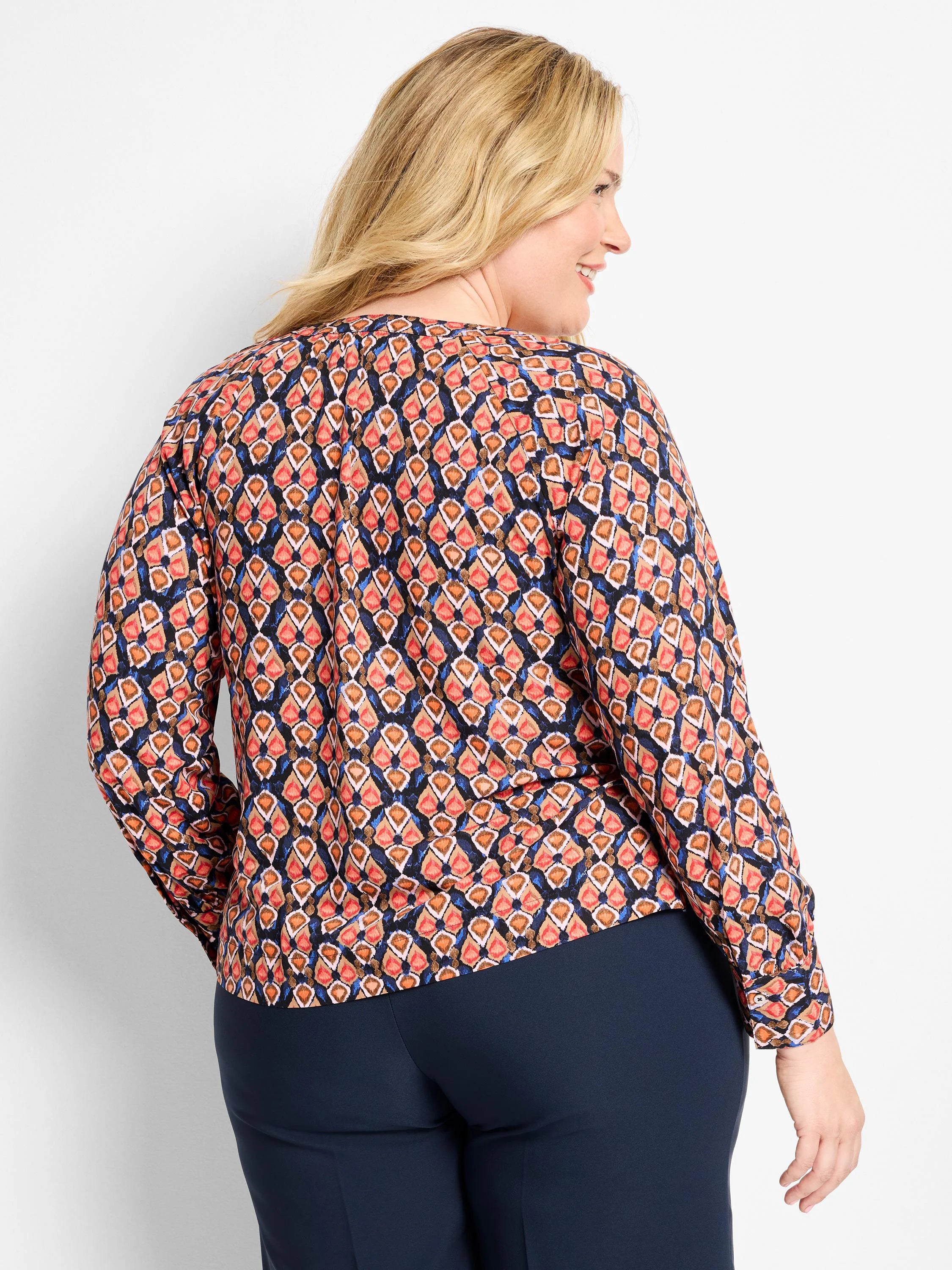 Long-sleeve top: geometric ikat pattern in dark blue, coral, tan, and accent blue.