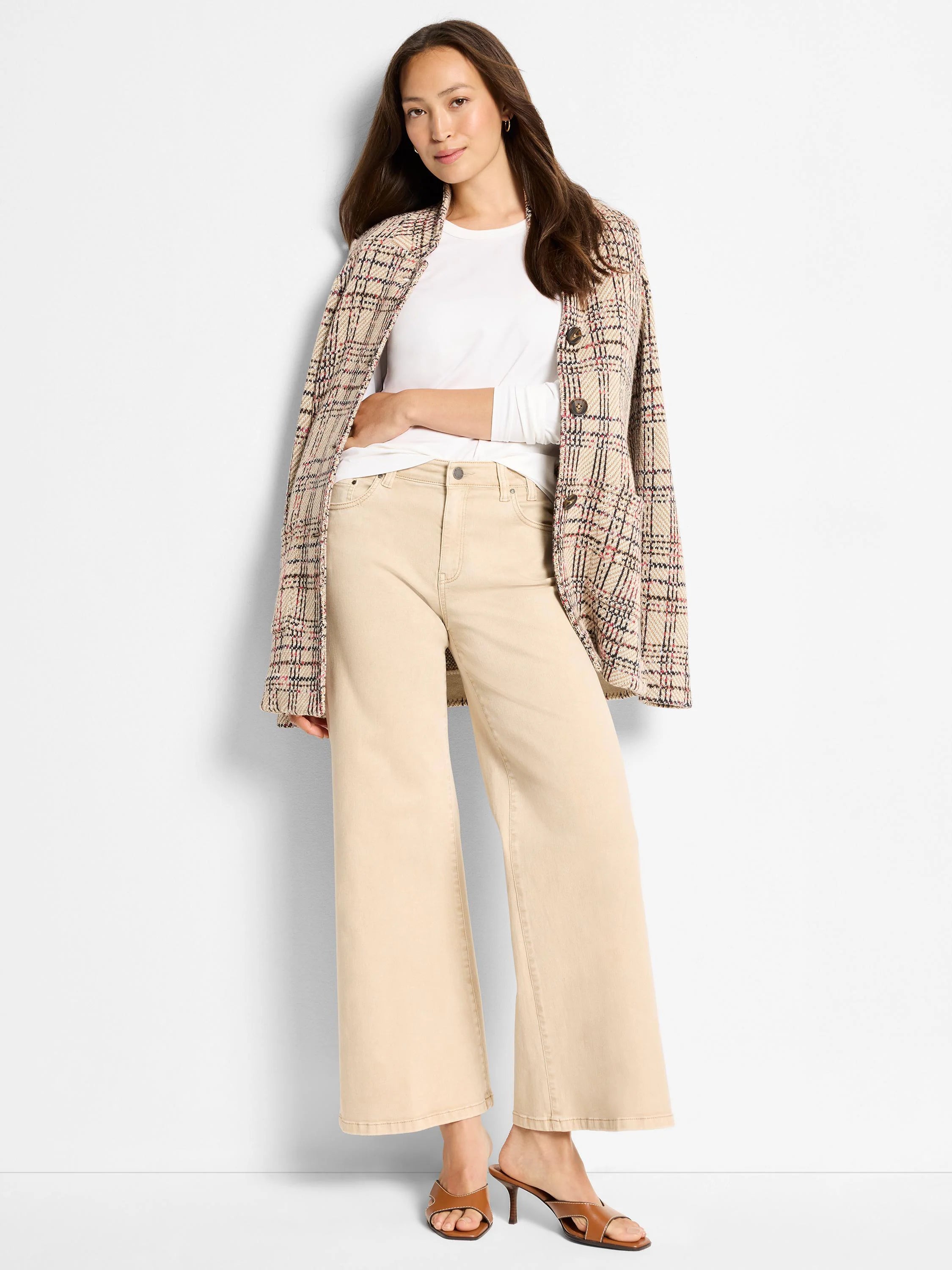 Light tan boot flare jeans with a wide leg, front button, zipper, and visible pockets.