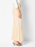 Cream boot-flare jeans with a high waist, standard pockets, and a wide hem, worn by a model.