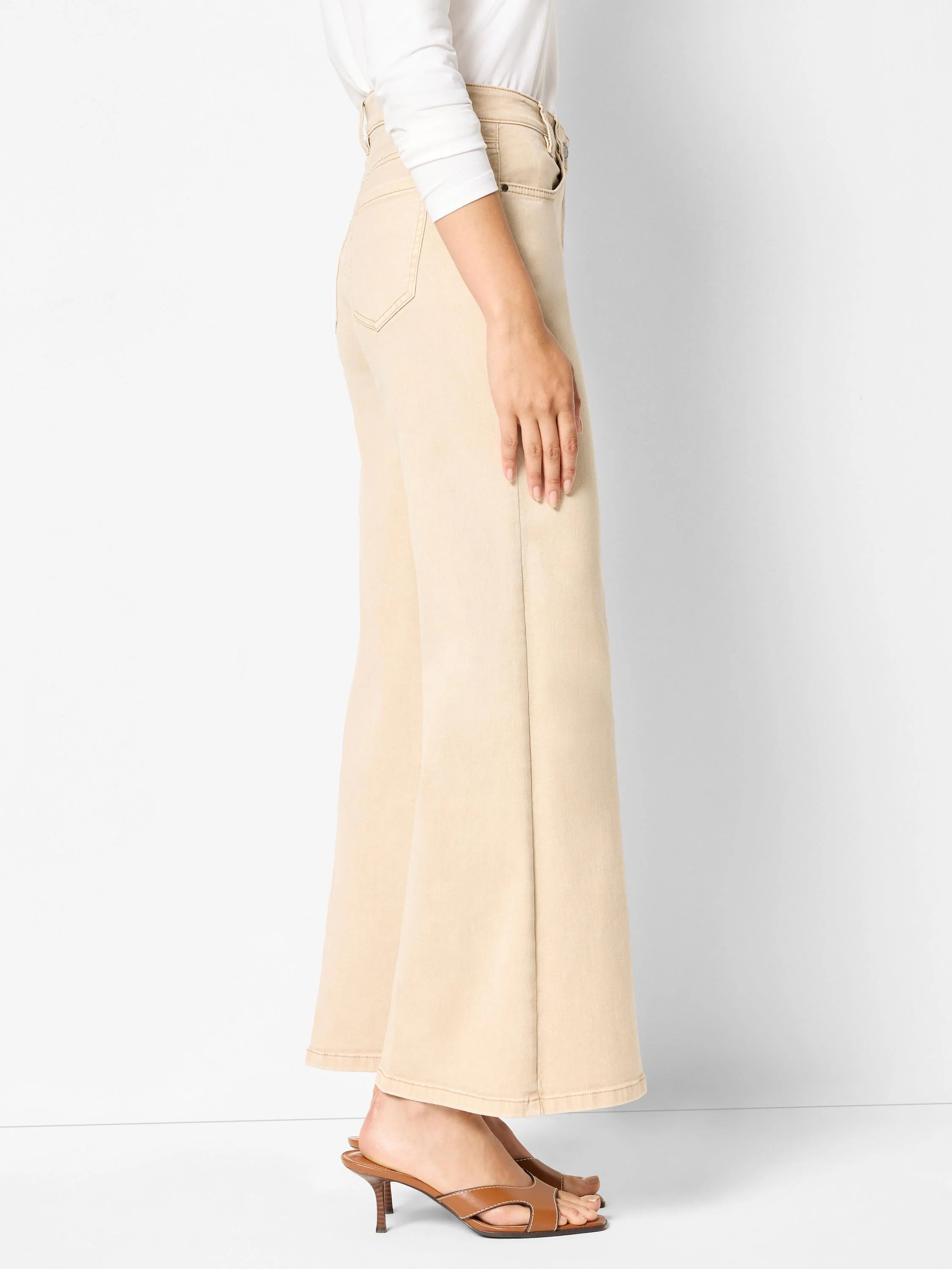 Cream boot-flare jeans with a high waist, standard pockets, and a wide hem, worn by a model.