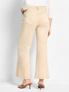 Back view of light tan boot flare jeans with visible back pockets and belt loops.