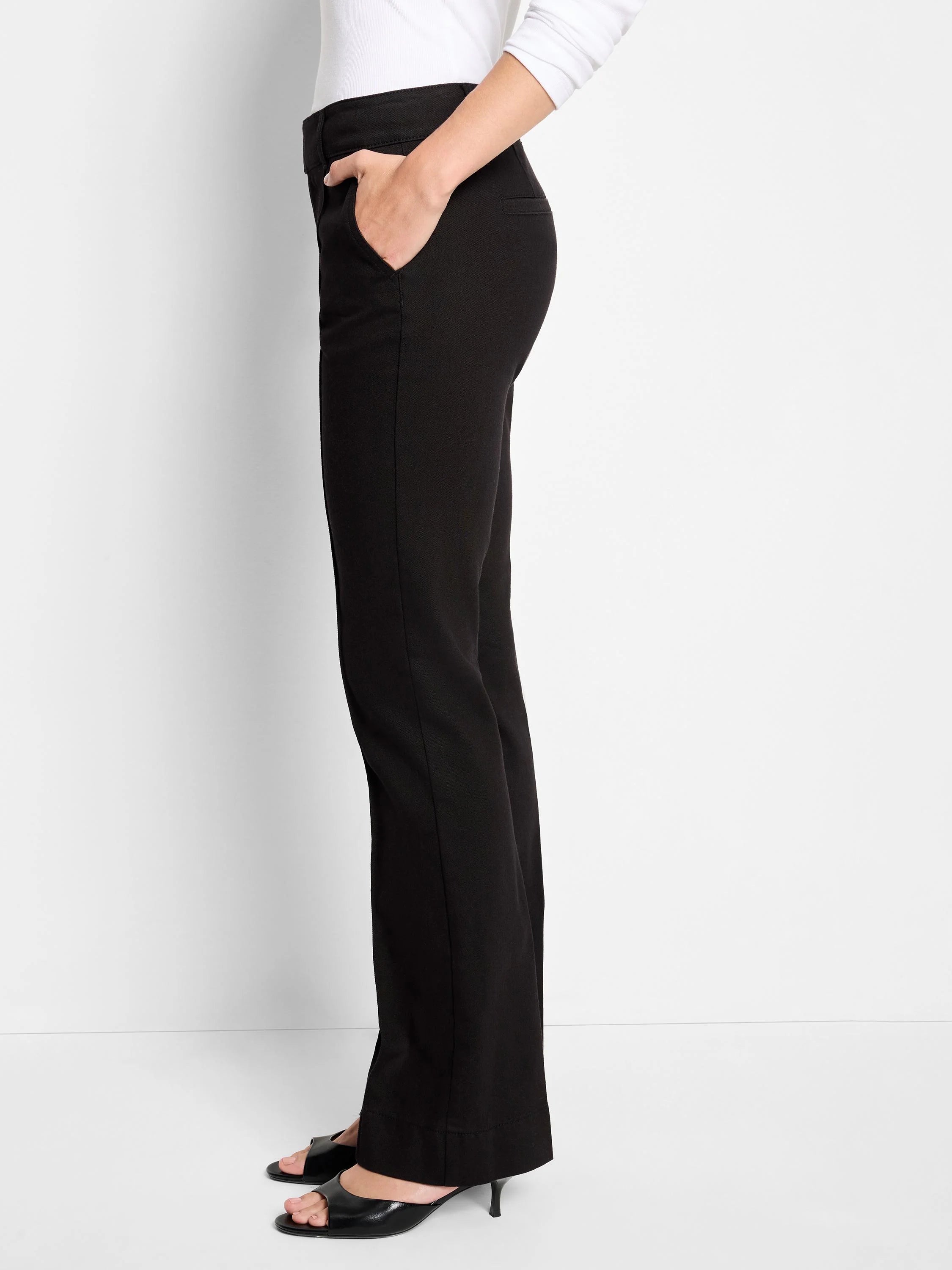 Black mid-rise bootcut trouser jeans, side view. Features smooth fabric, front pocket, and a subtly flared hem.