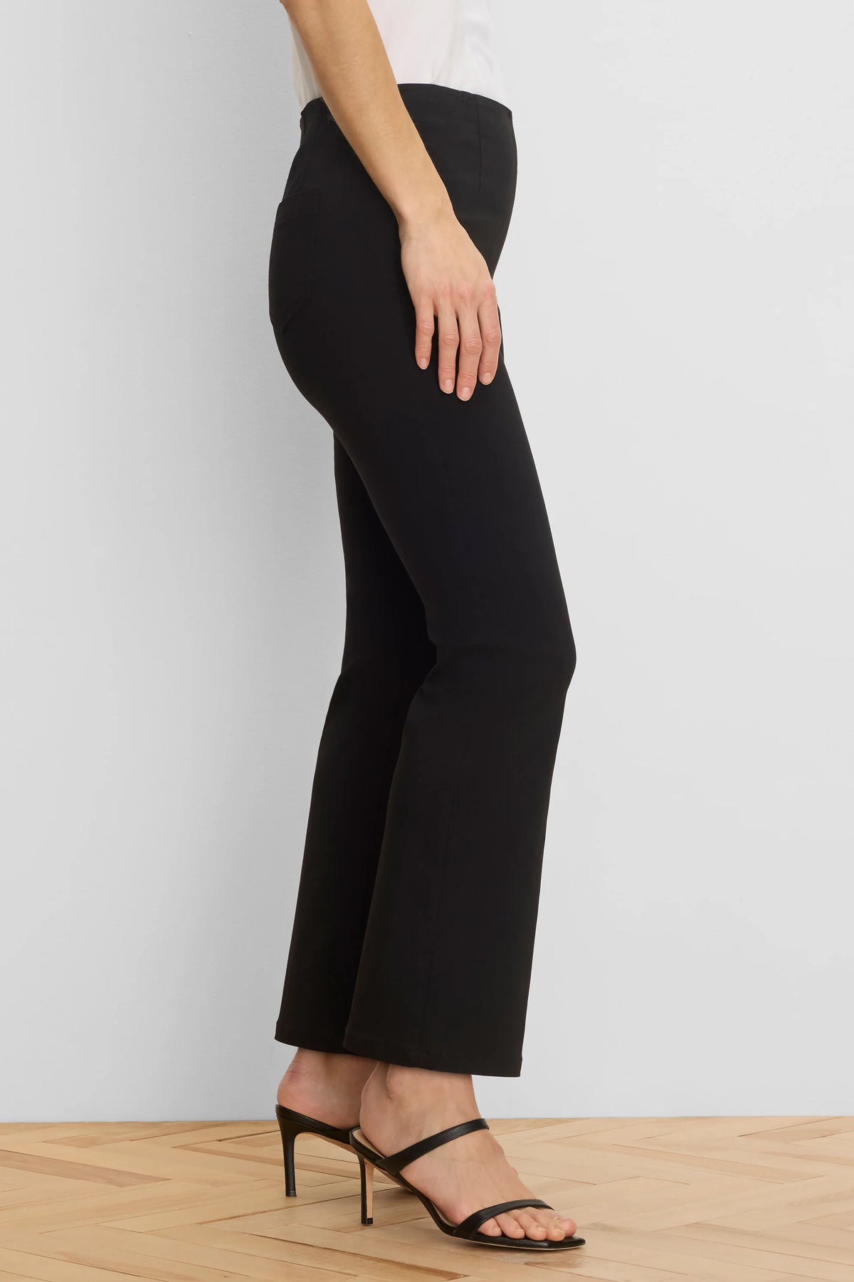 Black bootcut pants, fitted from a high waist through the thigh, with a slight flare at the ankle. Full length.