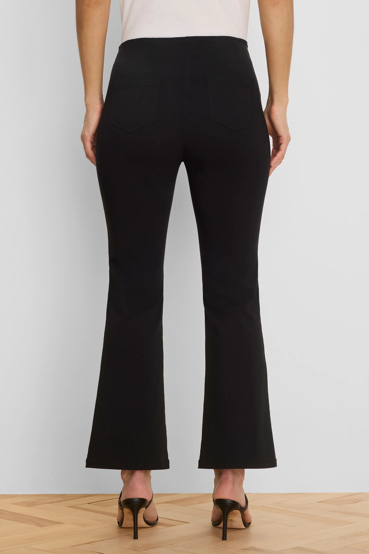 Black bootcut pants with two visible back patch pockets, shown from the rear on a model.
