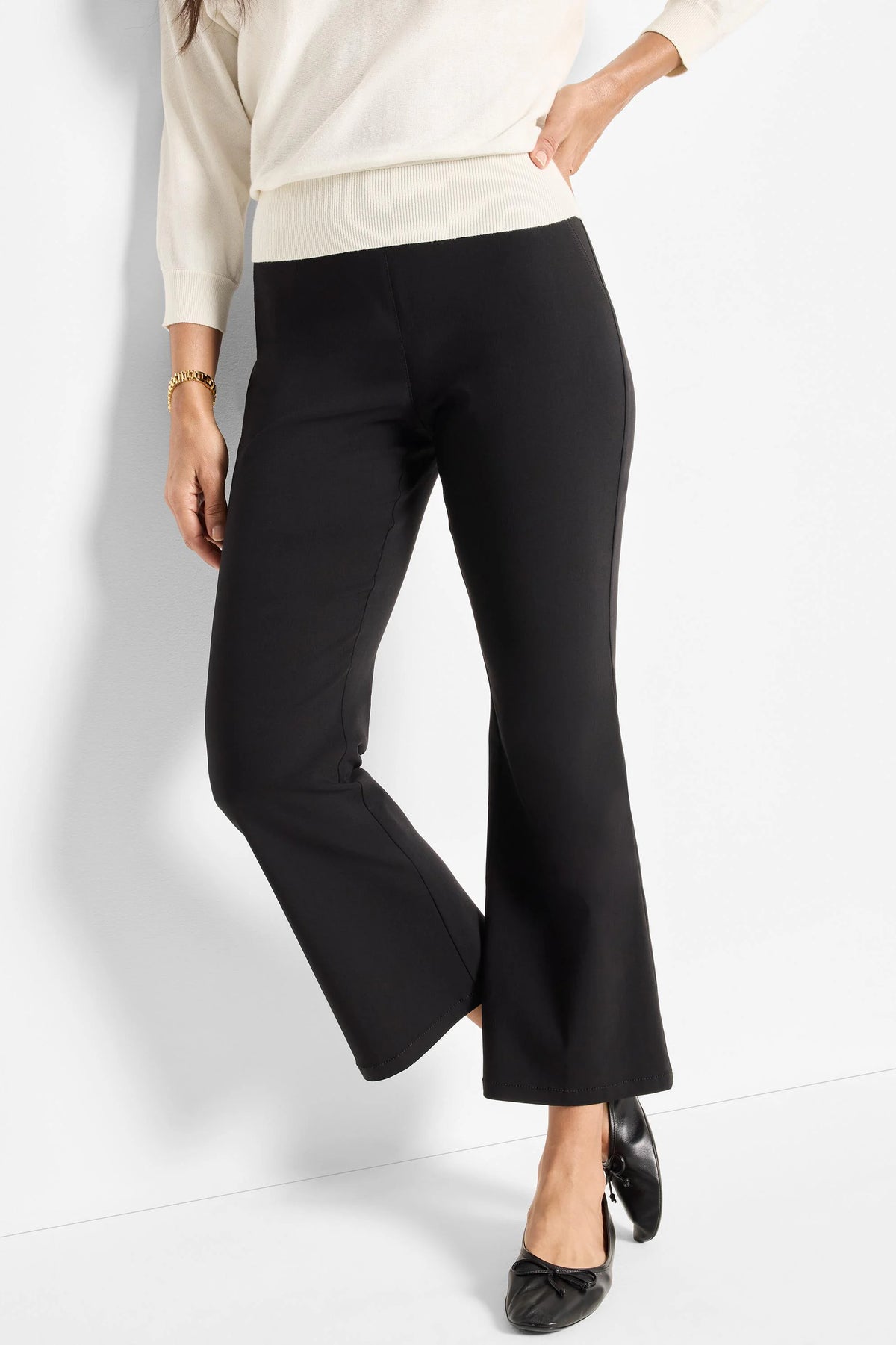 Black bootcut pants with a flat, smooth waistband. Full-length legs gently flare at the hem.